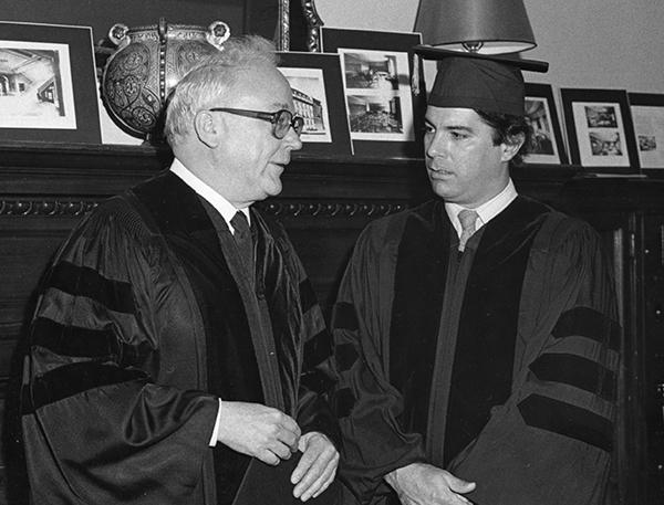 two men wearing graduation gowns